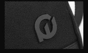 Detail of durable black woven fabric with minimalist circular logo on a crossbody bag