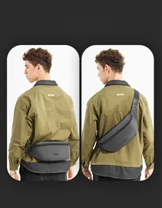 Détail du sac bandoulière gris foncé montrant les modes de port épaule et ceinture