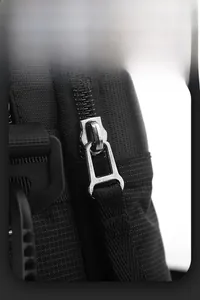 Detail of high-density nylon fabric texture and premium metal zipper on black shoulder bag