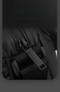 Close-up detail of smooth matte black zipper pull on durable nylon crossbody bag