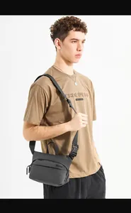 Detail view of the black nylon crossbody bag featuring an adjustable strap and quick-release buckle