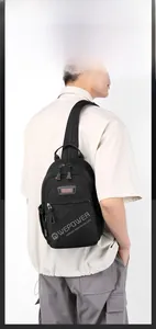 Détail du tissu mat imperméable et de la poche frontale zippée sur un sac de sport pour homme