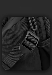 Detail of high-density nylon fabric and adjustable strap buckle on black shoulder bag