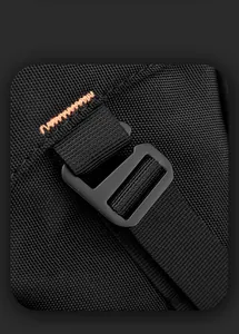 Detail of black sports bag showing heavy-duty fabric, plastic buckle and orange stitching