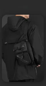 Close-up of black tactical chest bag with front buckle pocket and water resistant fabric
