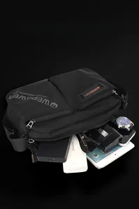 Detailed interior of a black canvas crossbody bag showing large storage space for gadgets