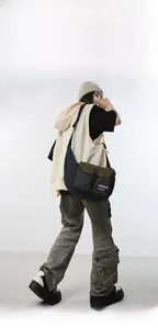 Detail of olive green and checkered crossbody bag worn with casual streetwear outfit
