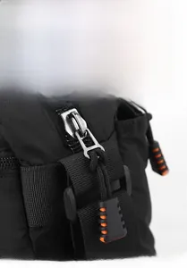 Detail of durable metal zipper with orange non-slip puller on black nylon shoulder bag
