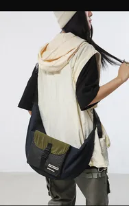Detail of adjustable strap and color-block crossbody bag featuring buckle closure