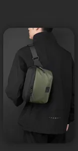 Close-up of army green and black crossbody bag with waterproof zippers and woven strap