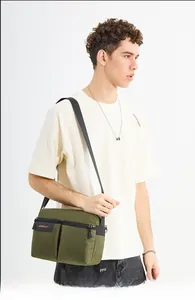 Detail view of military green canvas messenger bag with durable zippers and logo strap