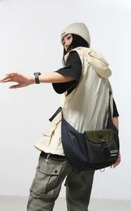 Detail showing high-capacity crossbody dumpling bag with wide shoulder strap on model