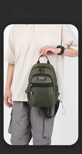 Homme tenant un sac de poitrine polyvalent en nylon vert armée pour loisirs et sport