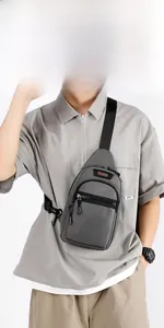 Detail view of grey crossbody chest bag with multiple zipper pockets and logo