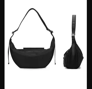 Detail view of the black crescent moon bag featuring adjustable straps and zipper closure