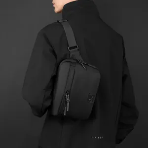 Minimalist black nylon sling bag for men worn by model, showing textured matte finish