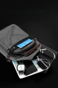 Gray nylon crossbody bag showing spacious interior compartments with multiple personal items