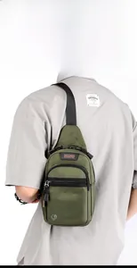 Rear view of model wearing an olive green nylon sling bag with adjustable strap