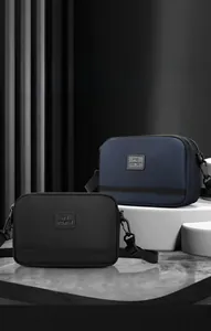 Détail de la texture imperméable et du logo WE POWER sur les sacs de sport croisés