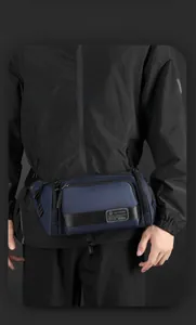 Close-up of durable navy waterproof waist bag with multiple layers and metal brand logo