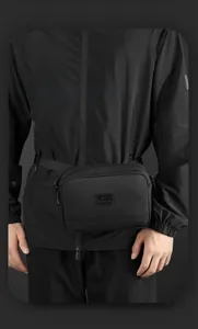 Détail de la texture en nylon et du logo sur ce sac banane de sport noir polyvalent