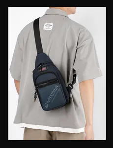 Detail showing back view of navy blue nylon sling bag with adjustable strap and multiple zippers