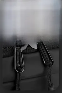 Detail of smooth metal zippers with nylon pull cords on black waterproof chest bag