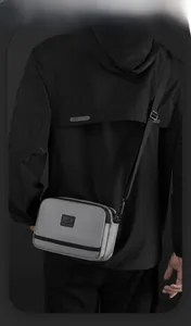 Détail du sac à bandoulière tactique gris montrant le tissu résistant et le logo
