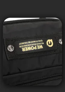 Close-up of black nylon fabric with woven brand label and metallic embossed rivets