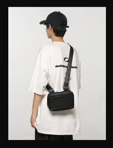 Détail de la bandoulière réglable en nylon noir et de la texture mate du sac de poitrine