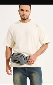 Close-up of gray nylon waist bag with yellow logo patch and multi-layer zippers