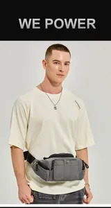 Detail of dark gray nylon fanny pack showing multiple zipper pockets and buckle