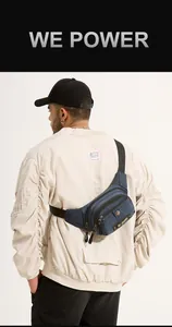 Detail view of a multi-layer dark blue nylon crossbody bag shown on a model