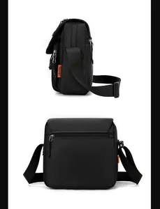 Detail view of black nylon crossbody bag featuring orange woven label and zipper pocket