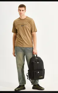 Front view of a black multi-pocket nylon backpack with a casual men's street outfit