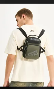 Detail view of olive green crossbody bag with adjustable strap on male model back