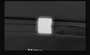 Dettaglio del punto riflettente di sicurezza anteriore sulla borsa da viaggio nera
