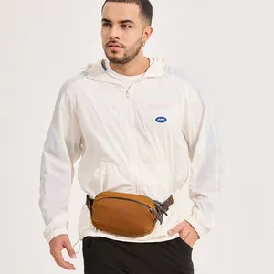 Men's caramel sports chest bag with adjustable strap worn over white hoodie