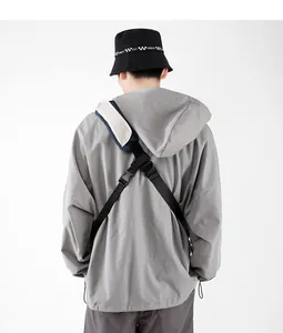 Rear view of grey hooded windbreaker with black bucket hat and crossbody bag detail