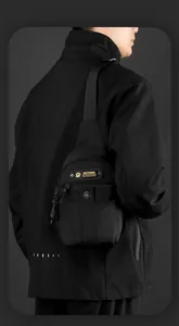 Close-up of black tactical crossbody bag with buckle detail and yellow branded label