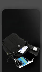 Detail view of multi-layer storage for black nylon crossbody bag with daily essentials