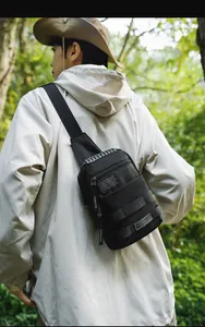 Tactical black nylon sling bag with MOLLE webbing shown in an outdoor forest setting