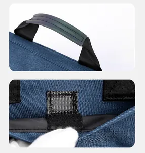 Detail of ergonomic padded handle and quick-access velcro pocket on navy messenger bag