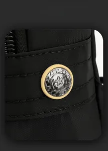 Detailed close-up of black nylon fabric texture and circular logo on crossbody bag