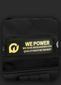 Macro detail of high-quality black nylon fabric and yellow woven label on shoulder bag