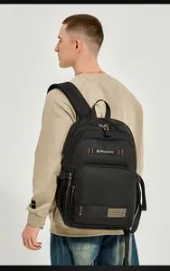 Detailed view of casual black backpack with multi-zipper pockets and orange stitching accents