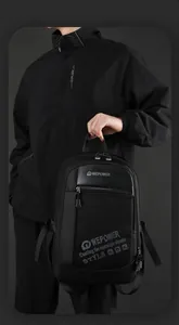 Detail of a black multi-compartment backpack with brand logo and premium nylon texture