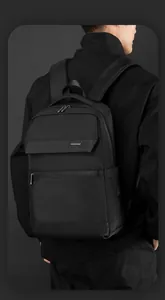 Rear view of model wearing a sleek black business laptop backpack with water-resistant fabric