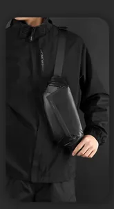 Détail du sac bandoulière noir mat imperméable avec boucle magnétique et logo