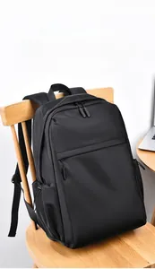 Detail of black water-resistant business backpack placed on a chair near a laptop